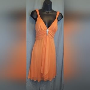 Orange party dress with jeweled brooch.